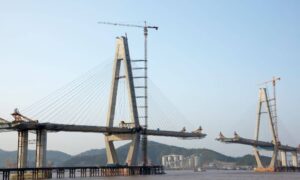 Bridge construction over river showing geotechnical engineering challenges during low water levels