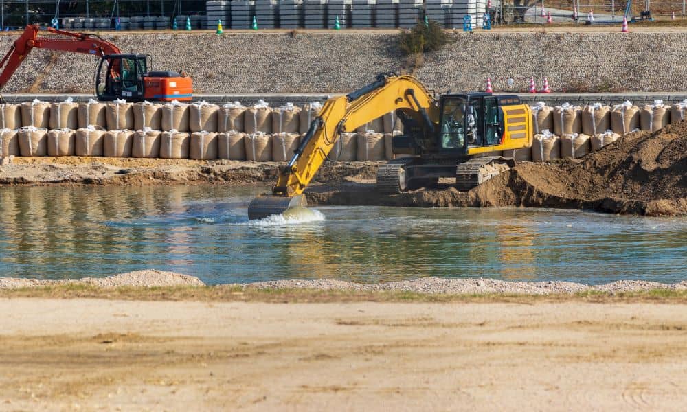 Construction site with excavators, earthwork, water, and sediment control measures observed during a construction survey