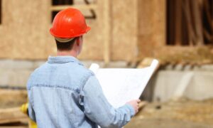 Construction engineer in Memphis reviewing blueprints at a building site