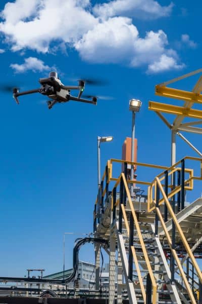 Drone surveying above a construction site to capture aerial data
