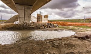 Bridge construction site showing stormwater pooling beneath structure, highlighting the importance of modern stormwater design