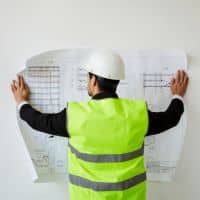 Survey plans being reviewed during a property survey for permit approval
