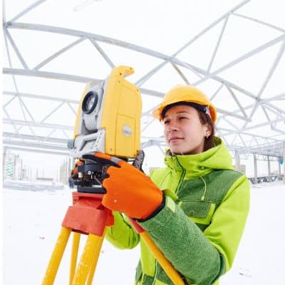 Land surveyor using professional equipment to perform accurate survey mapping on site