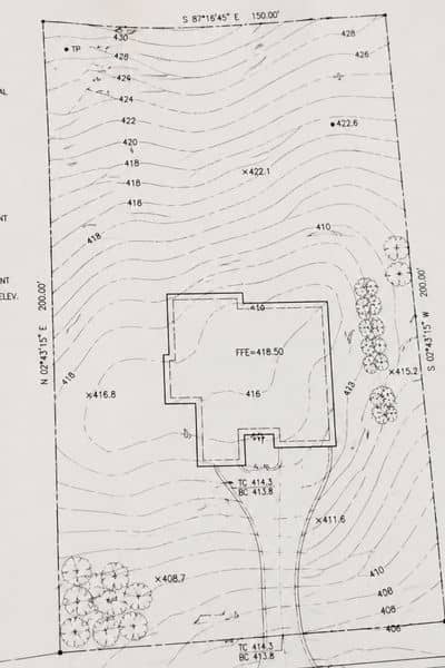 A close-up of a topographic survey showing contour lines and elevation changes across a property