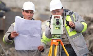 Surveyor reviewing property plans with equipment - ALTA SURVEY Tennessee Surveyors reviewing property plans and equipment to understand property survey cost before starting fieldwork
