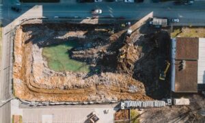 Aerial view of a construction site beside a road and adjacent properties for an ALTA survey