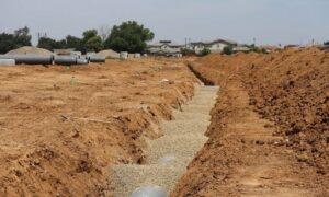 Construction site with staged pipes and an open trench, illustrating site conditions considered in a due diligence survey