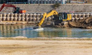 Construction site with excavators, earthwork, water, and sediment control measures observed during a construction survey